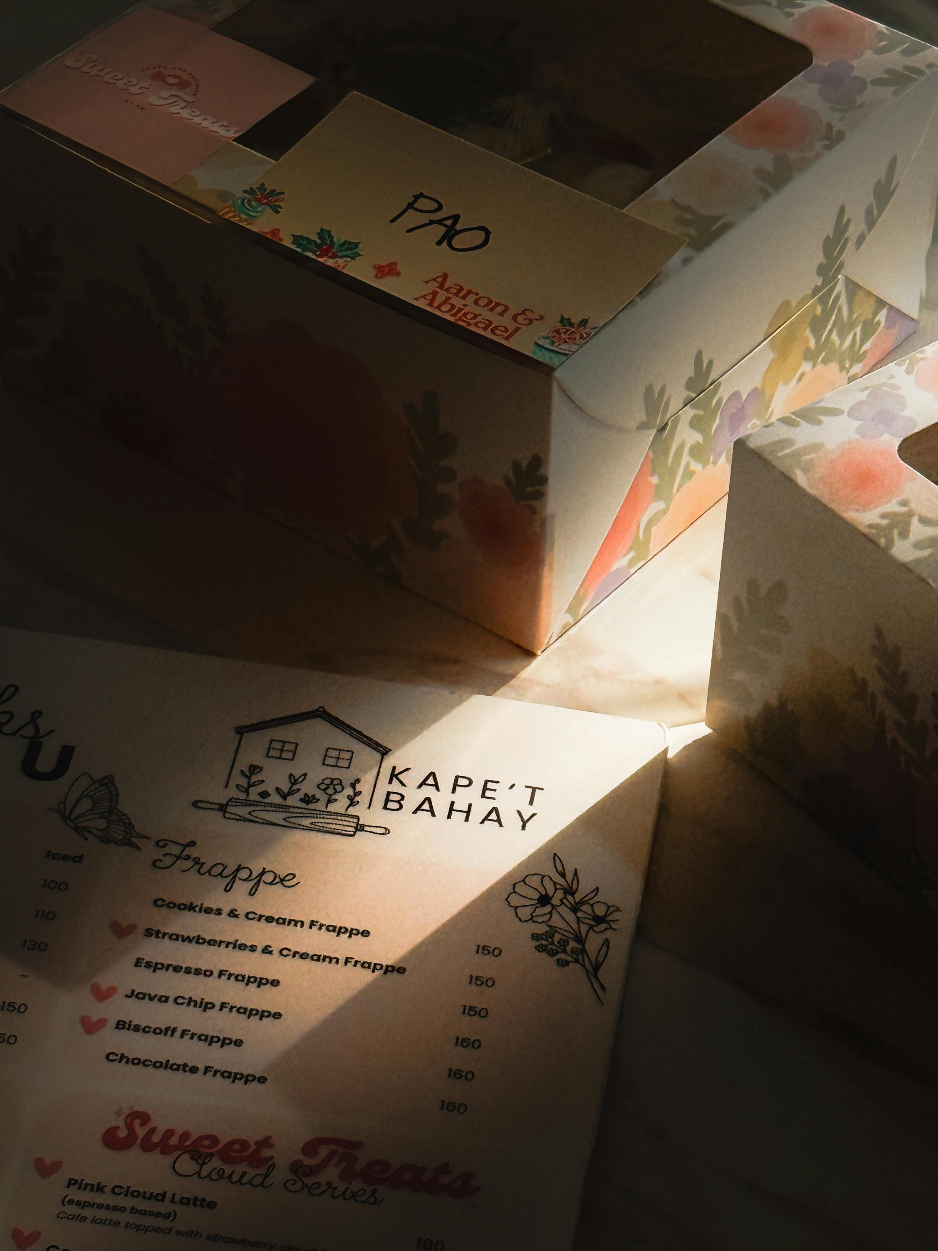 De franc Caixes de fleca florals i menú a la càlida llum del sol, creant un ambient acollidor i atractiu. Foto d'estoc