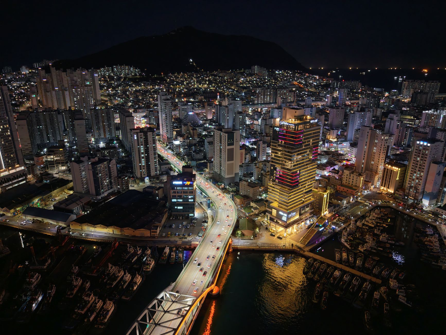 Stunning aerial shot of Busan, South Korea, at night showcasing a vibrant cityscape and illuminated skyline.