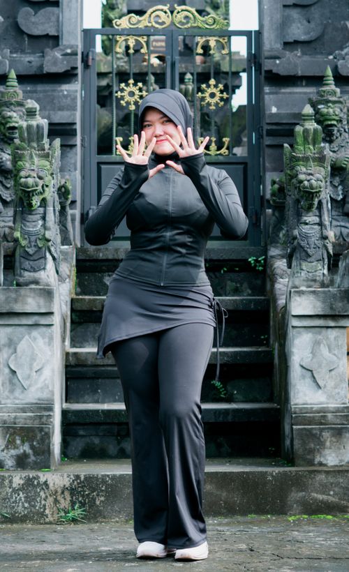 Free Asian woman in black outfit posing confidently at a traditional temple in Banten, Indonesia. Stock Photo