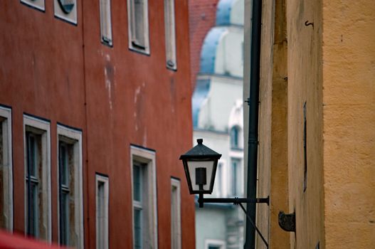 A picturesque view of a vintage lantern in a narrow alleyway, highlighting Regensburg's historic architecture.