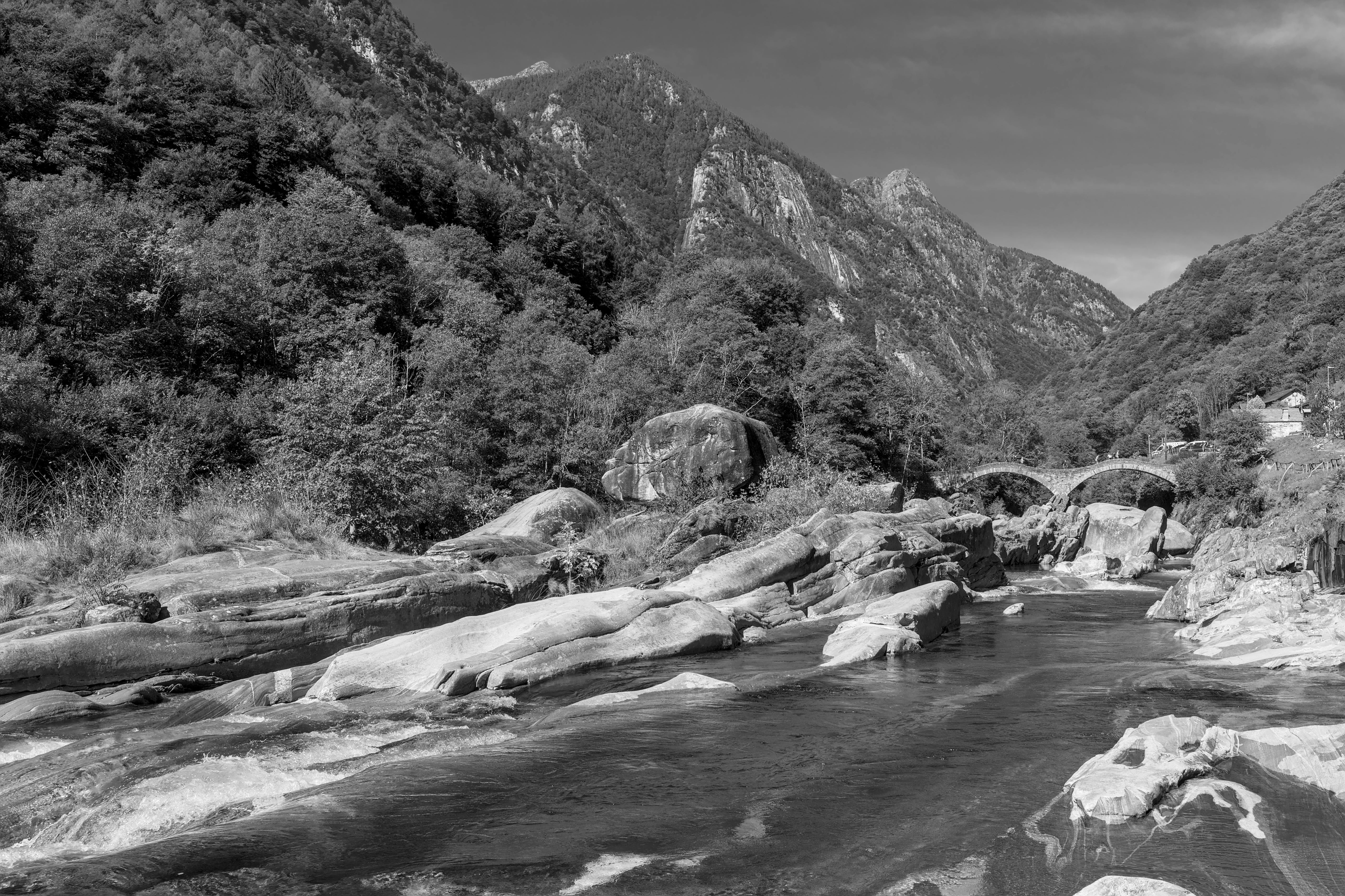 Picturesque view of Valle Verzasca featuring a historic stone bridge amidst mountains and river. - Valle Verzasca