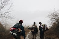 三位徒步旅行者在一条雾气弥漫的冬日小径上探索，展现了冒险精神与自然之美