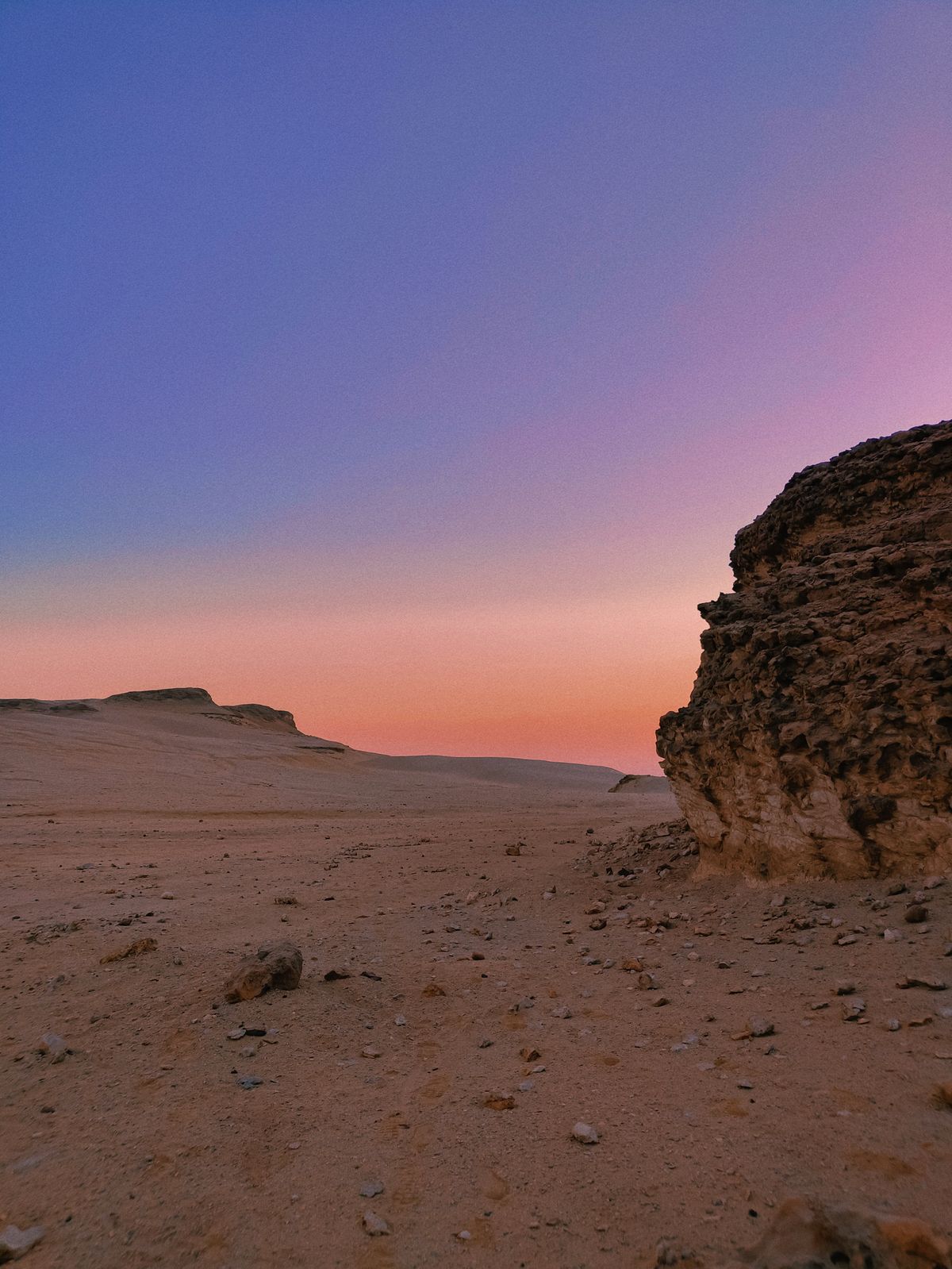 Kleurrijke schemering over een open woestijnlandschap in Egypte