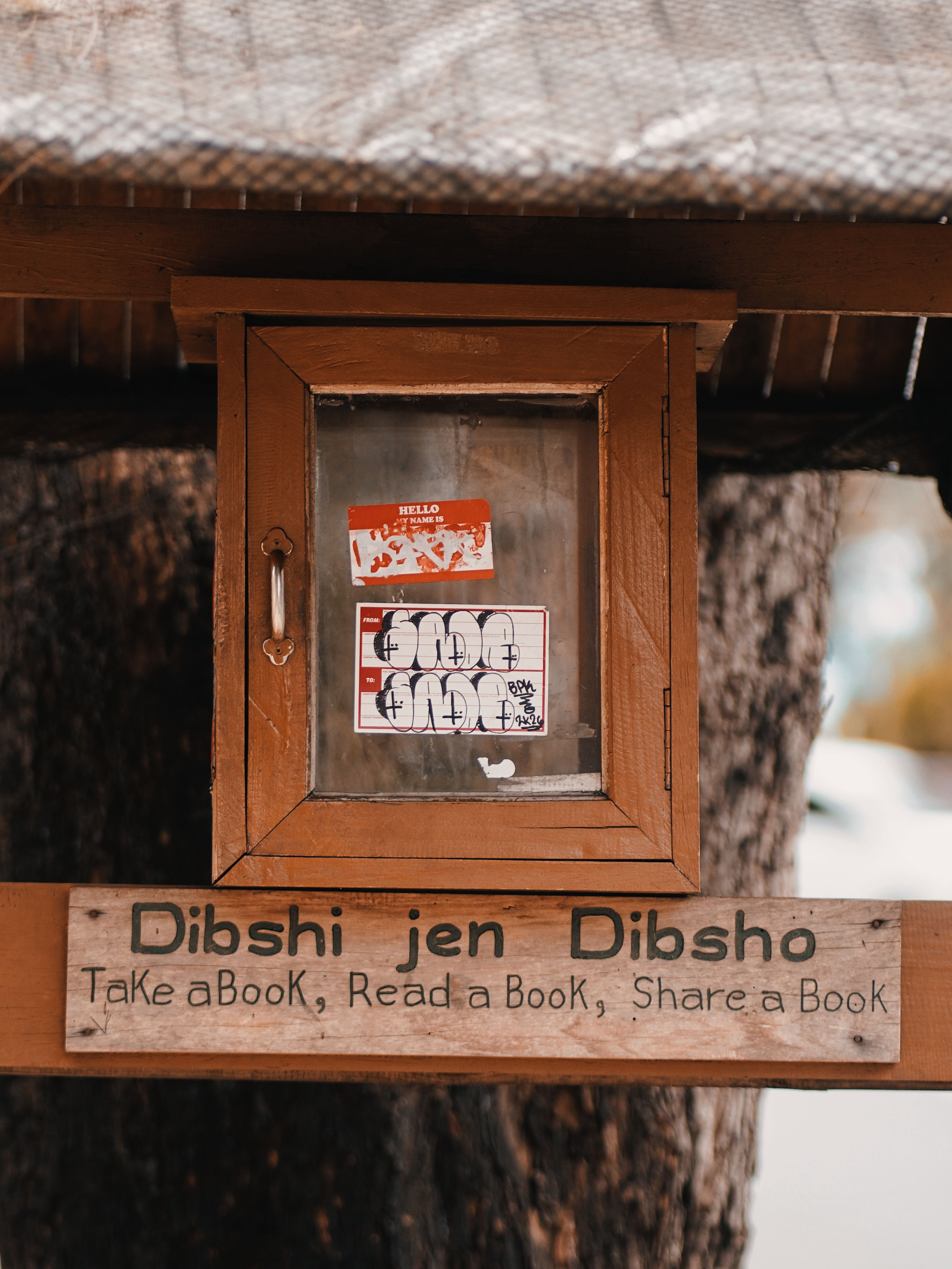 A rustic outdoor book exchange box encouraging sharing and reading.