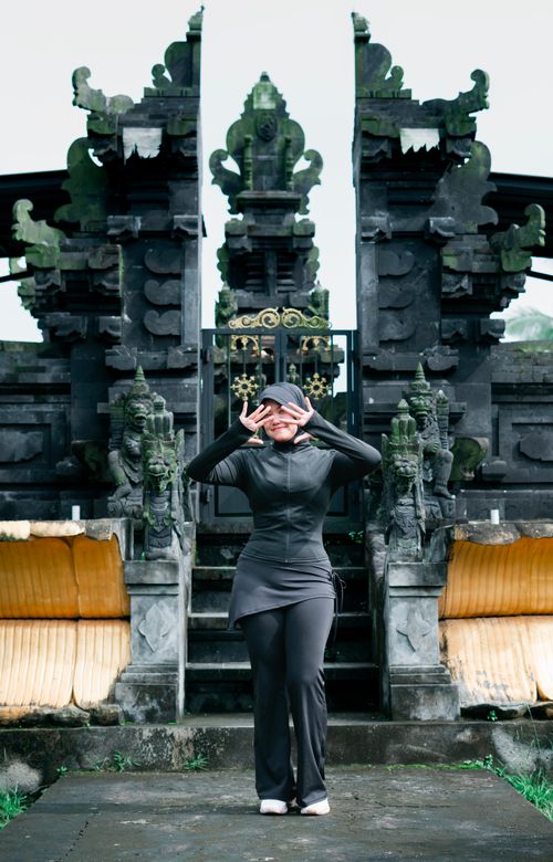 Free A serene portrait of a woman in front of a traditional temple gate in Banten, Indonesia. Stock Photo