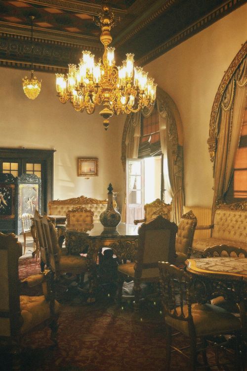 Free Luxurious vintage dining room featuring a grand chandelier and ornate furniture. Stock Photo