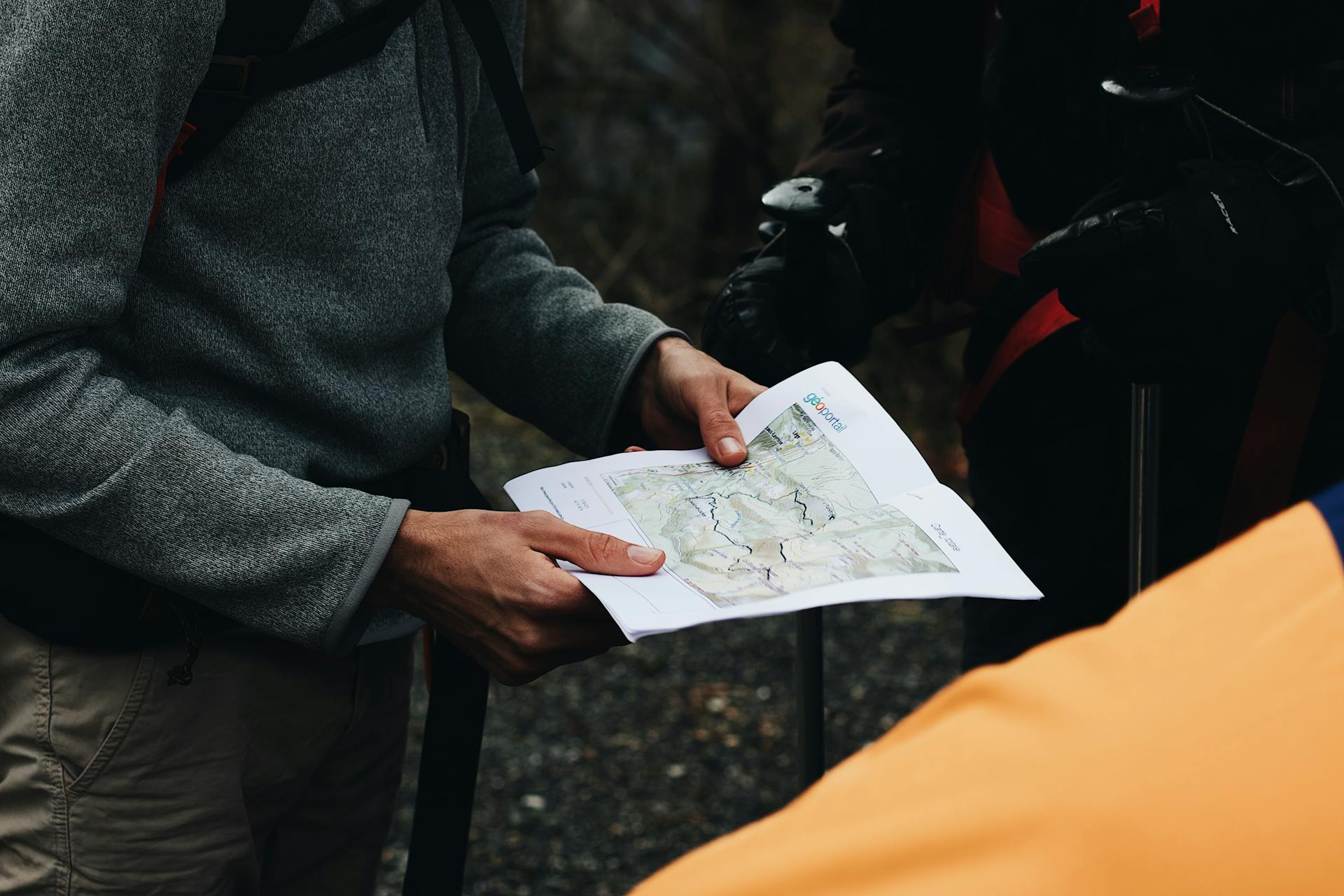 Group of hikers planning their route with a map during an outdoor adventure.