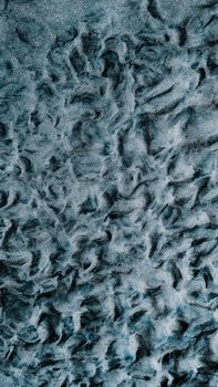 Aerial view of textured sand dunes with intricate wave patterns, creating a mesmerizing and natural abstract feel.