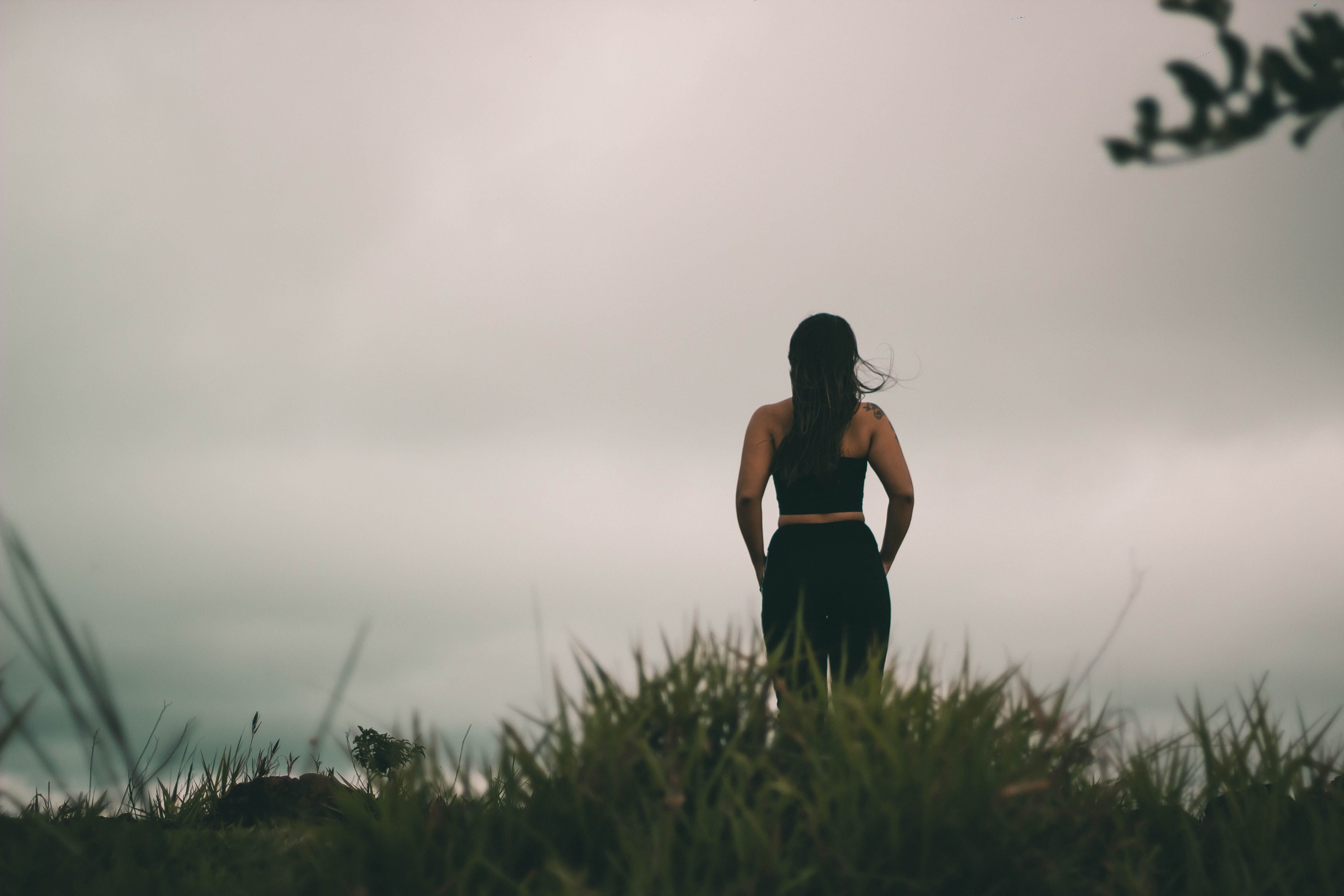 Woman in Black Tank Top Standing on Green Grass Field · Free Stock Photo