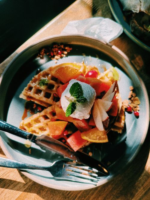 Free Colorful waffles topped with fresh fruits and mint garnish, perfect for a vibrant breakfast. Stock Photo