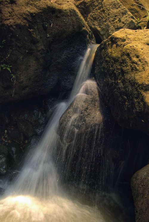 Free Beautiful waterfall cascading over rocks in the lush landscape of West Java, Indonesia. Stock Photo