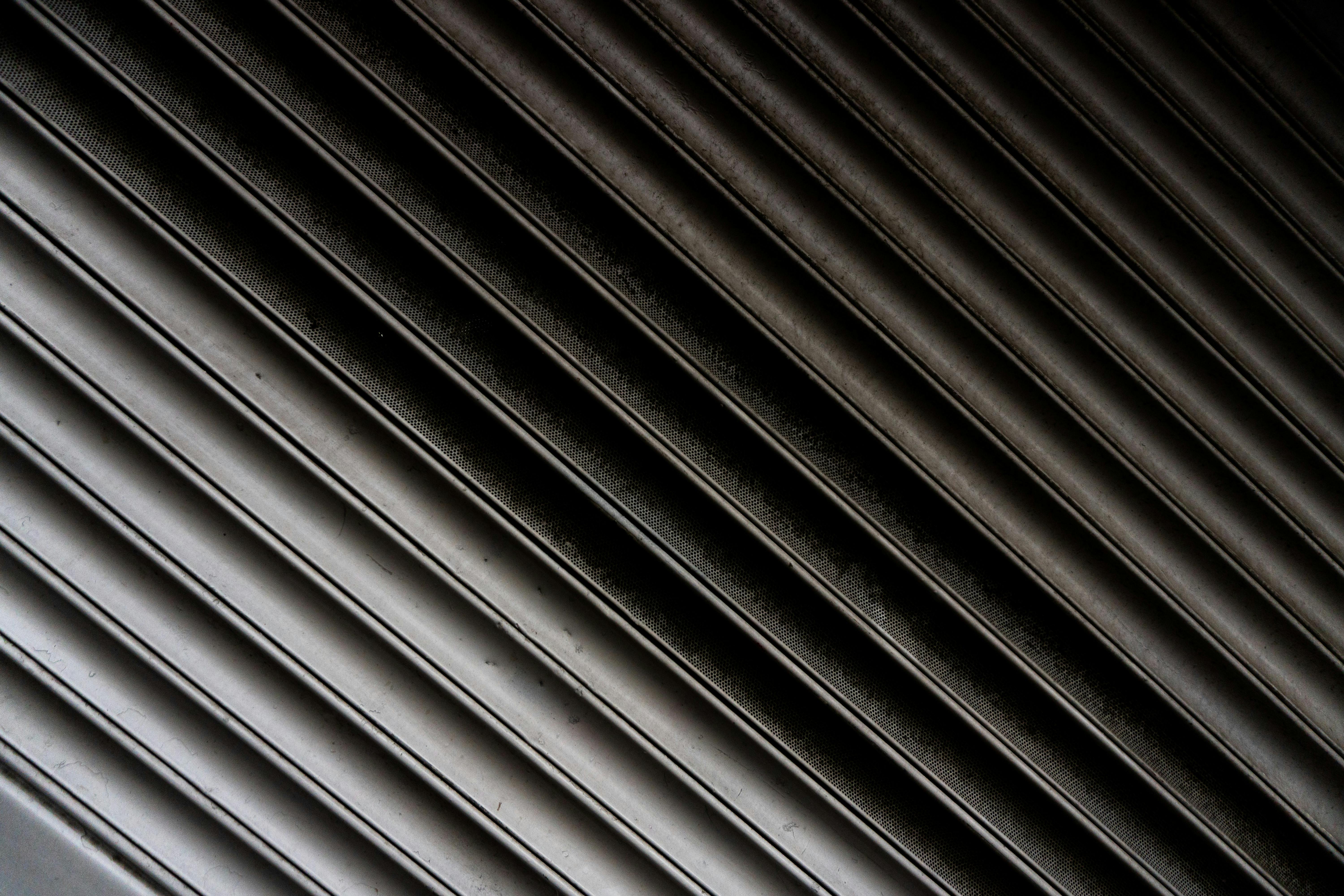 Zadarmo Detailný záber textúrovaného kovového povrchu s diagonálnymi čiarami vytvárajúcimi abstraktný priemyselný vzor. Fotka z fotobanky