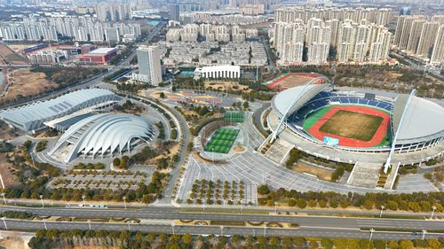 Free Aerial view showcasing a large stadium with modern architecture amidst an expansive urban setting. Stock Photo