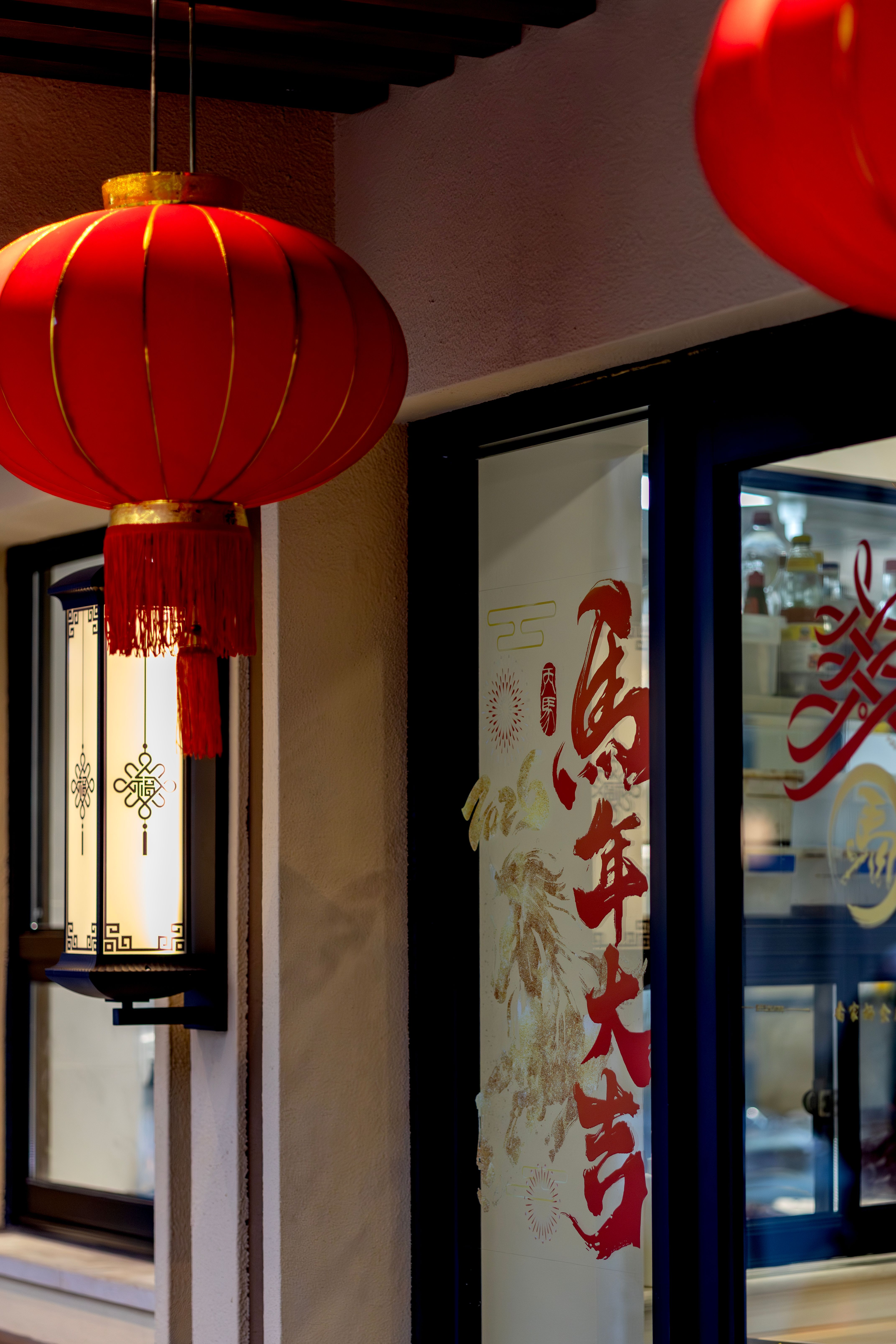 Red Asian lanterns and traditional designs enhance a quaint shop's exterior.