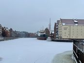 Snowy canal view with Narodowe Muzeum Morskie, Gdańsk, Poland.