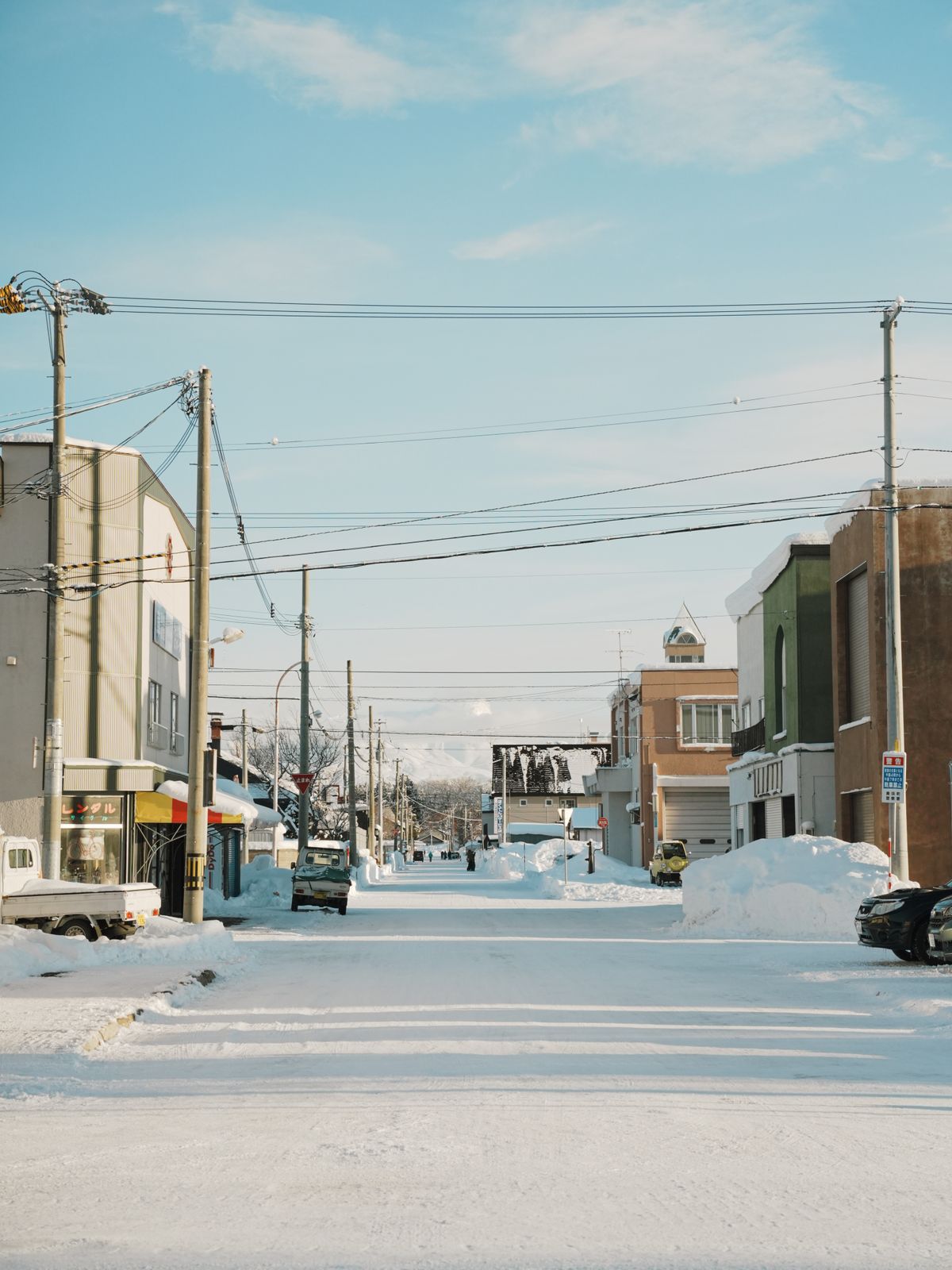 Quiet snowy street in Hokkaido during winter showcasing urban architecture