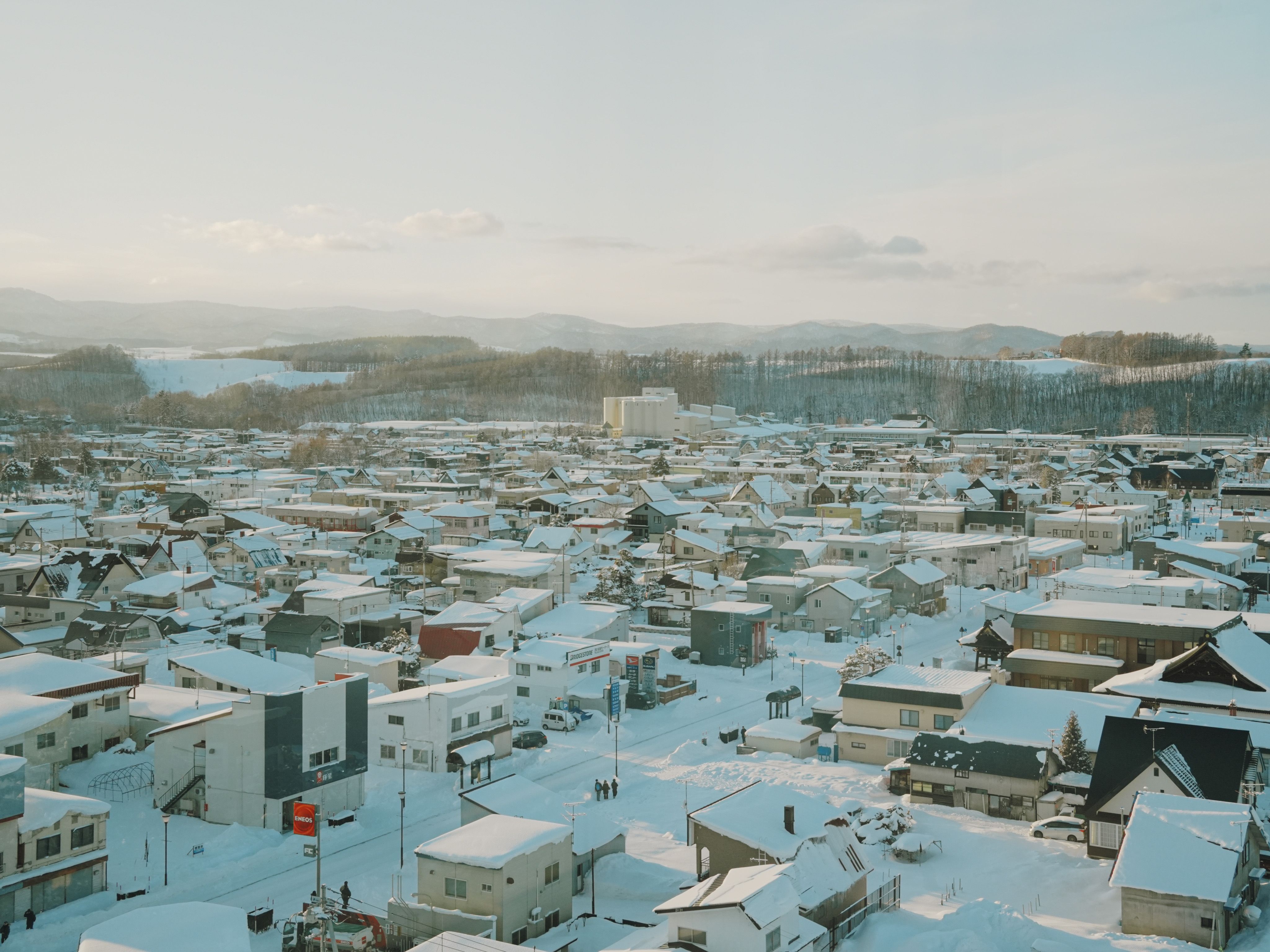A tranquil aerial shot of a snow-covered town in Hokkaido, Japan during winter.