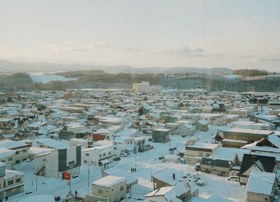 A tranquil aerial shot of a snow-covered town in Hokkaido, Japan during winter.