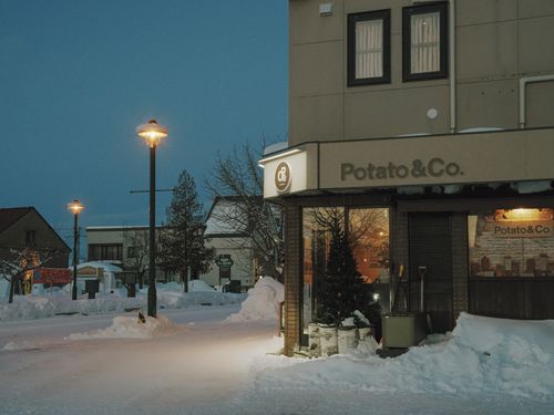 Free Snowy street in Hokkaido, Japan with cozy shops and streetlights at night. Stock Photo