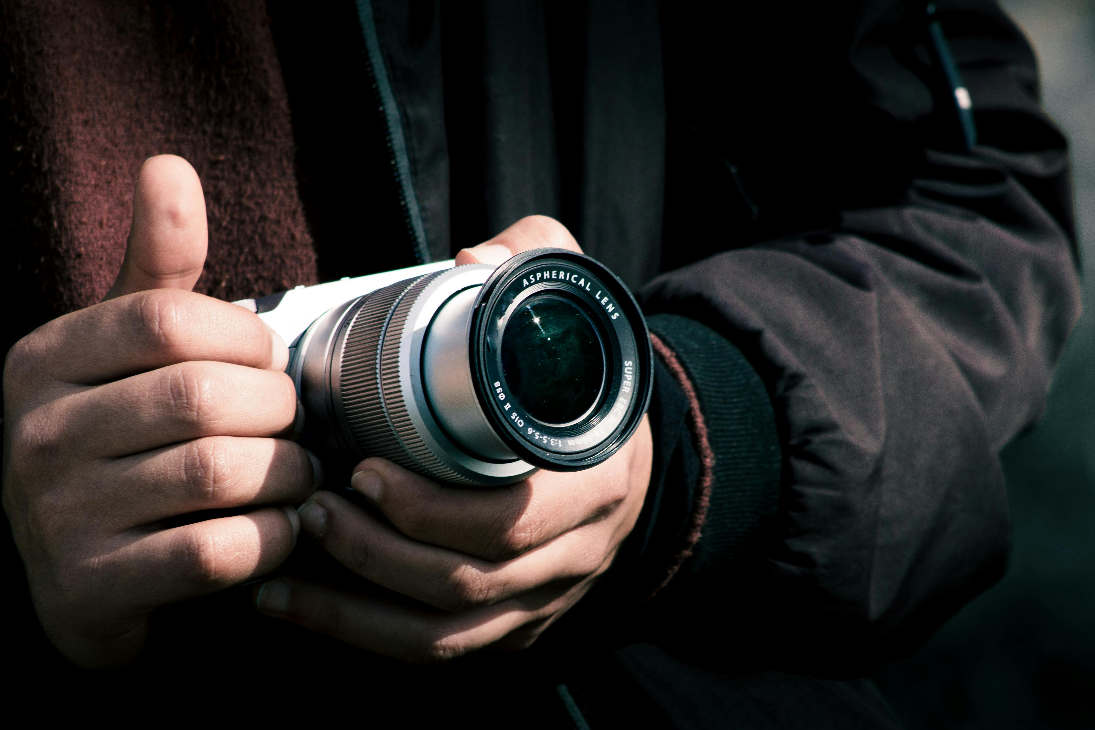 grátis Mãos segurando uma lente de câmera antiga, enfatizando o hobby e o interesse pela fotografia. Foto profissional