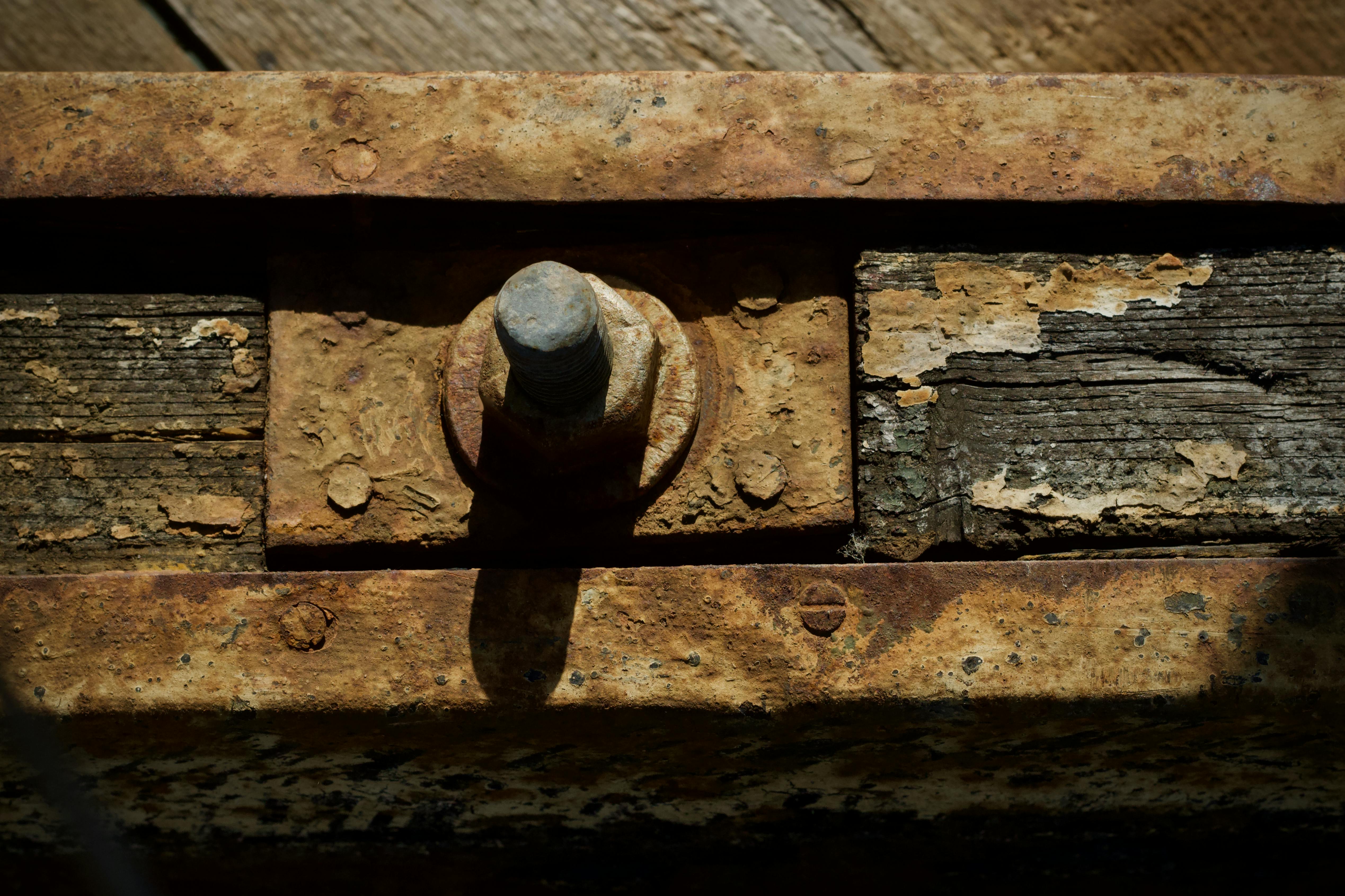 gratis Gedetailleerde macro-opname van een roestige bout in oud hout, die het verval laat zien. Stockfoto