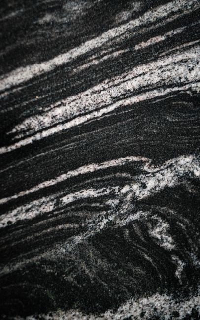 Close-up view of black and gray sedimentary rock texture with natural patterns and layers.