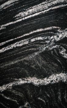 Close-up of a dark marble surface showcasing intricate natural patterns and mineral textures.