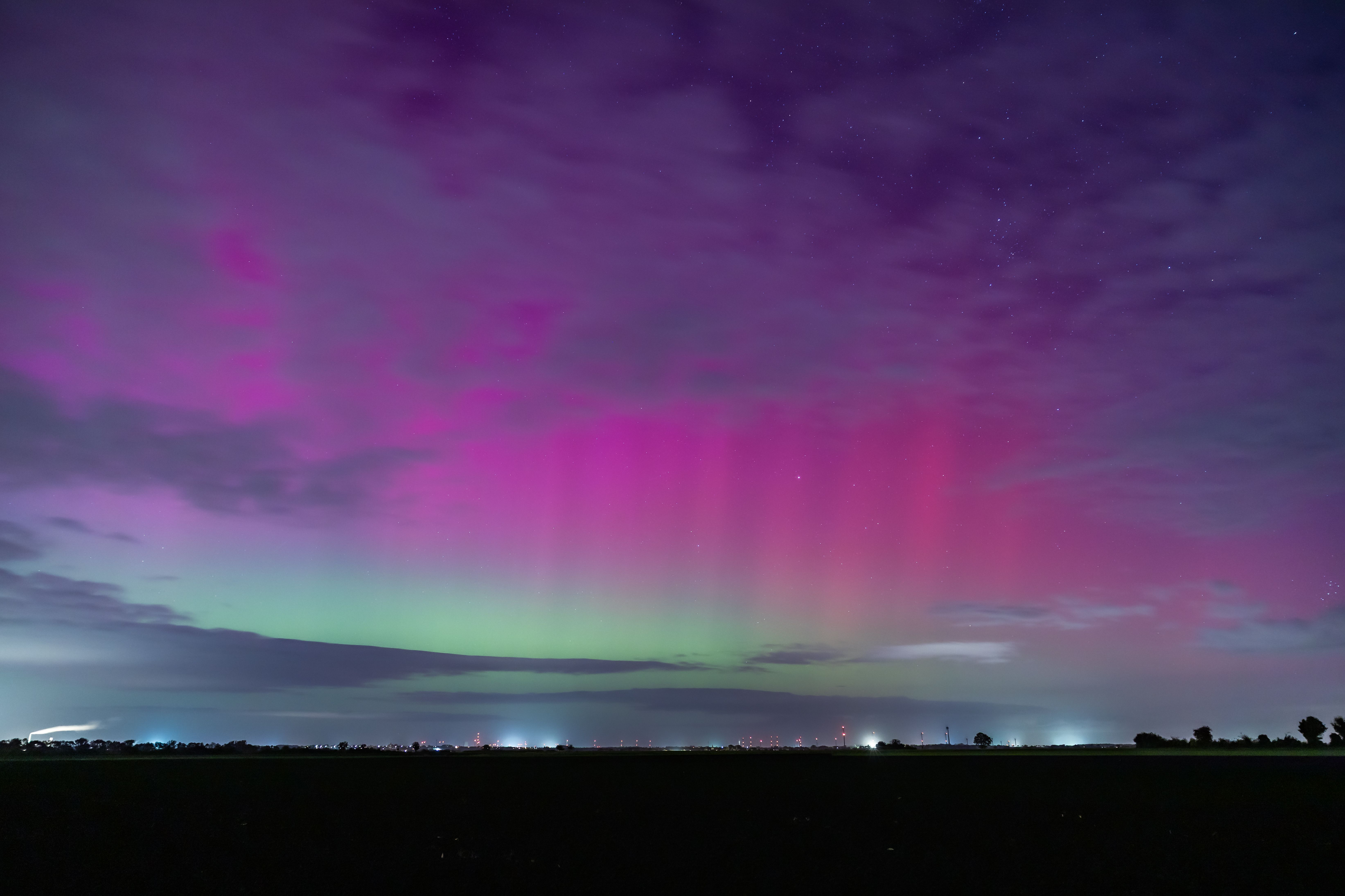 A vivid display of the aurora borealis in the night sky with purple and green hues.