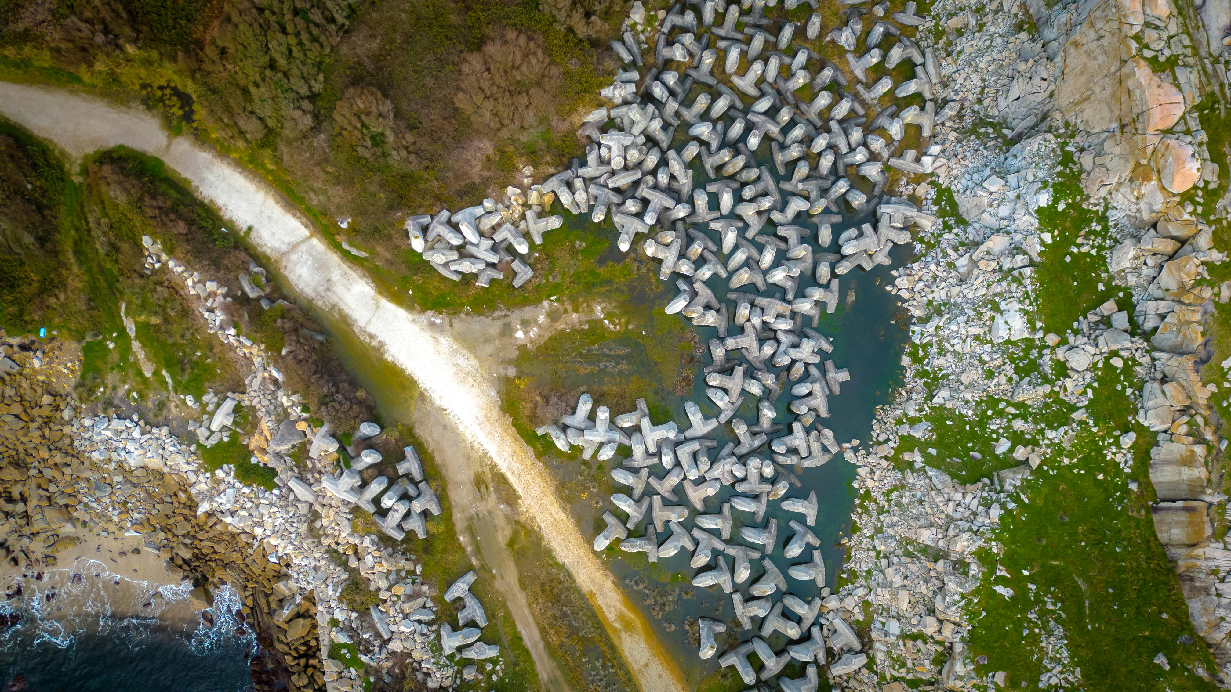 Stunning aerial view of dolos structures along the coast of Lugo, Spain, highlighting the rugged coastline.