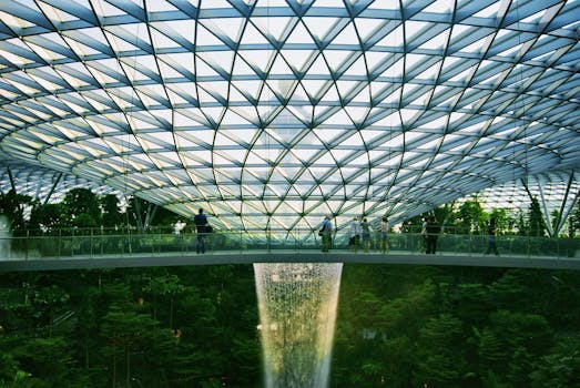 Explore the stunning architecture of Jewel Changi Airport in Singapore featuring its iconic indoor waterfall and garden.