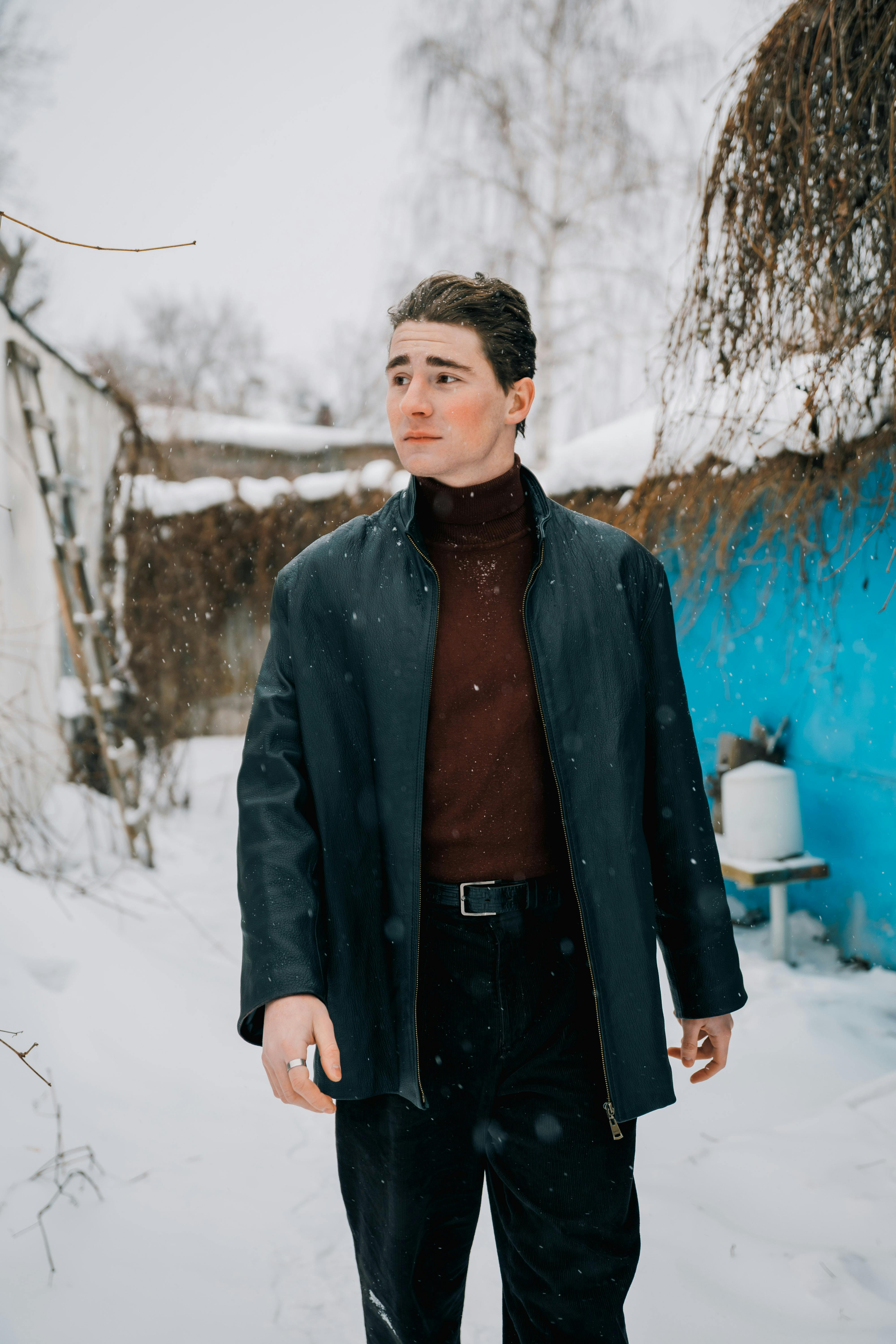 Zadarmo Muž v zimnom kabáte kráča zasneženým vonkajším prostredím, pôsobí štýlovo a pokojne. Fotka z fotobanky