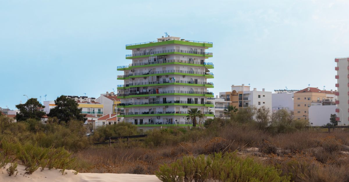 View of modern apartment buildings from a sandy beach in Monte Gordo, Portugal.