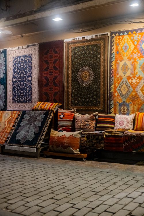 Free A colorful display of traditional oriental rugs and cushions in a rustic indoor setting. Stock Photo