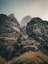 Dramatic rocky peaks and mist in the rugged Scottish Highlands landscape.