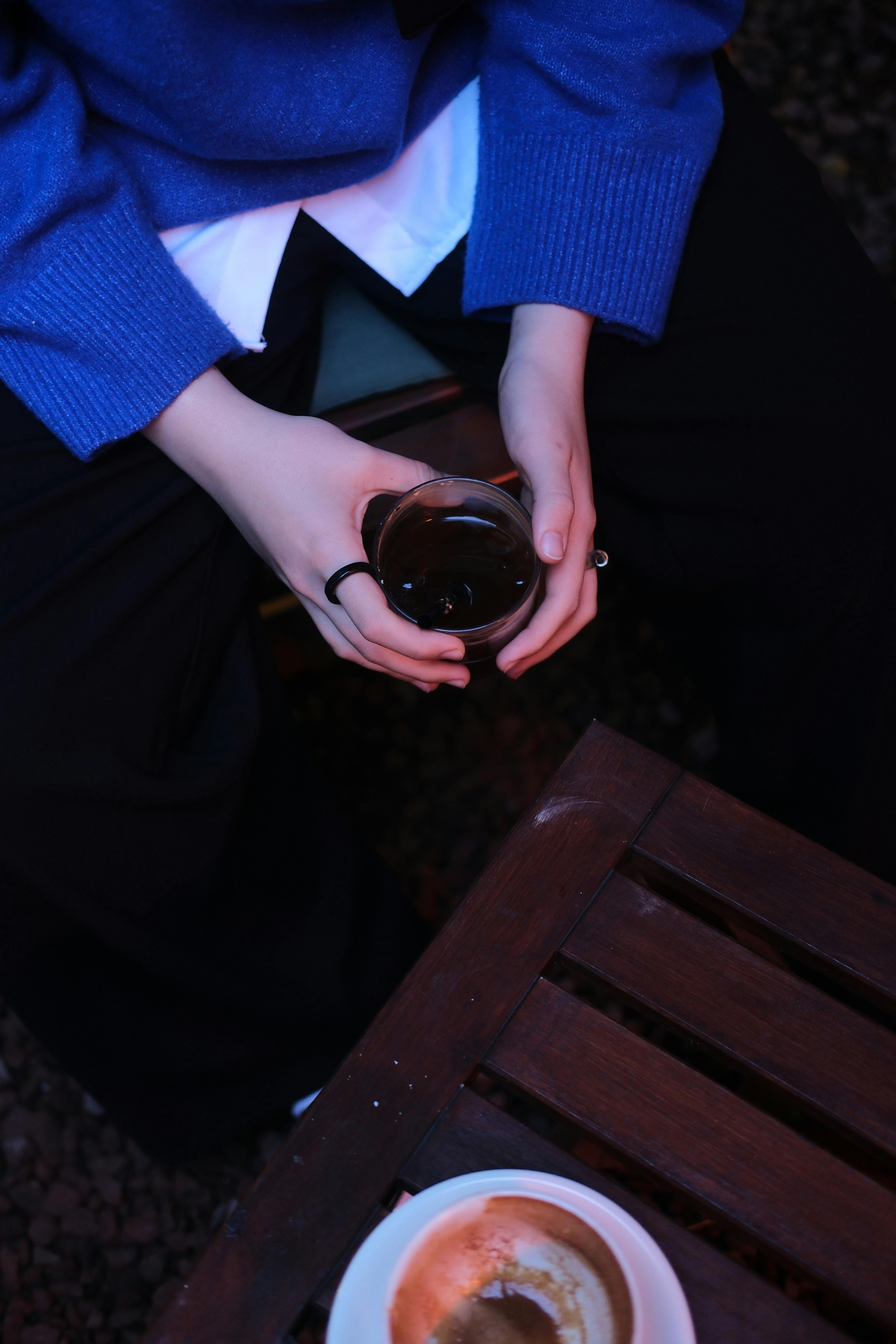 無料 涼しい夜の屋外でコーヒーカップを持つ手のクローズアップ。 写真素材