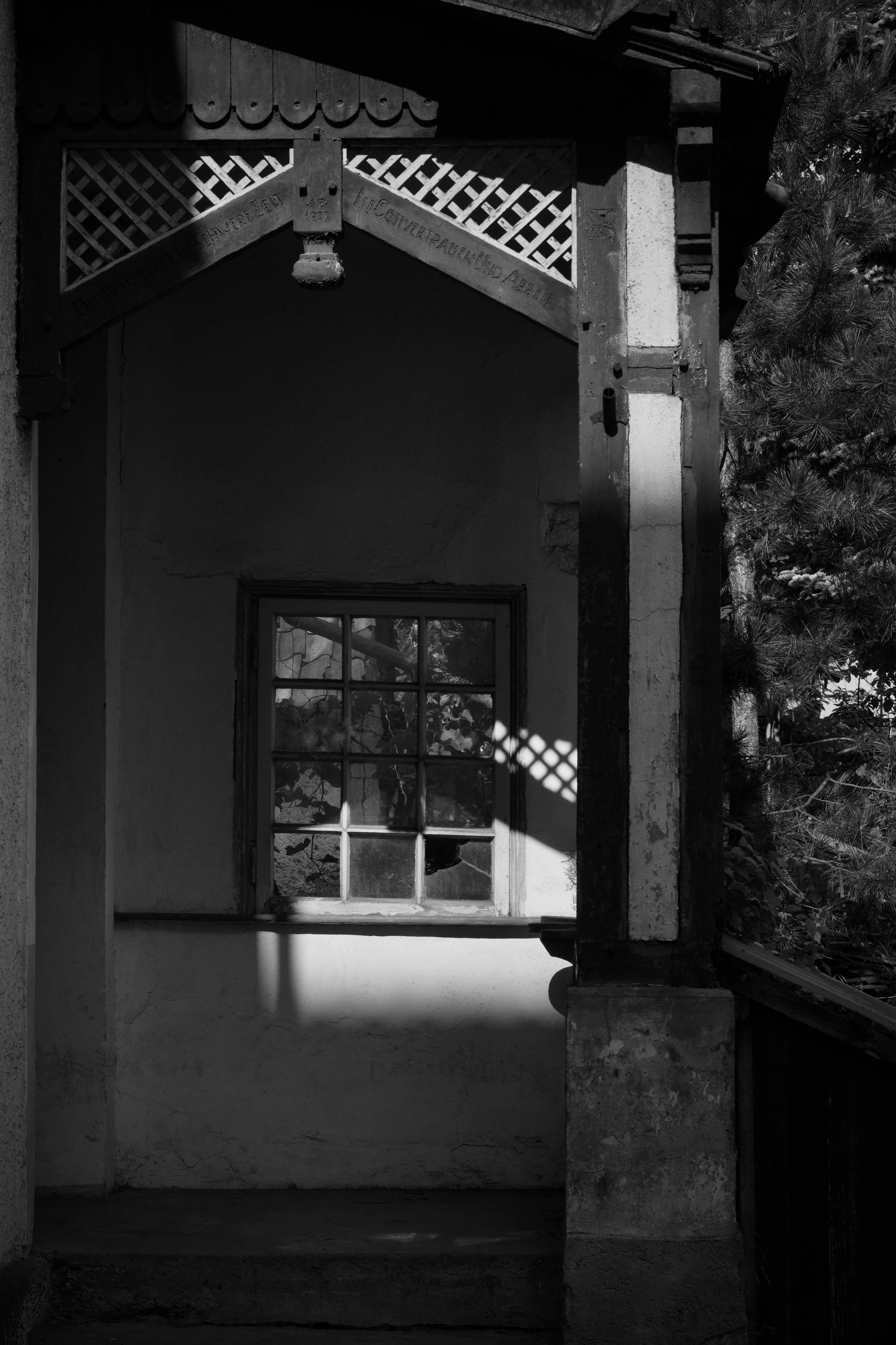 Gratuit Photo en noir et blanc d'ombres projetées à travers une fenêtre historique, créant une scène architecturale spectaculaire. Photos