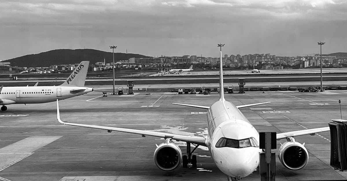 Photo by Reyhan Monochrome image of an airplane parked at the airport runway ready to board passengers.