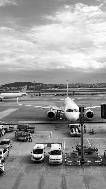 Photo by Reyhan Monochrome image of an airplane parked at the airport runway ready to board passengers.