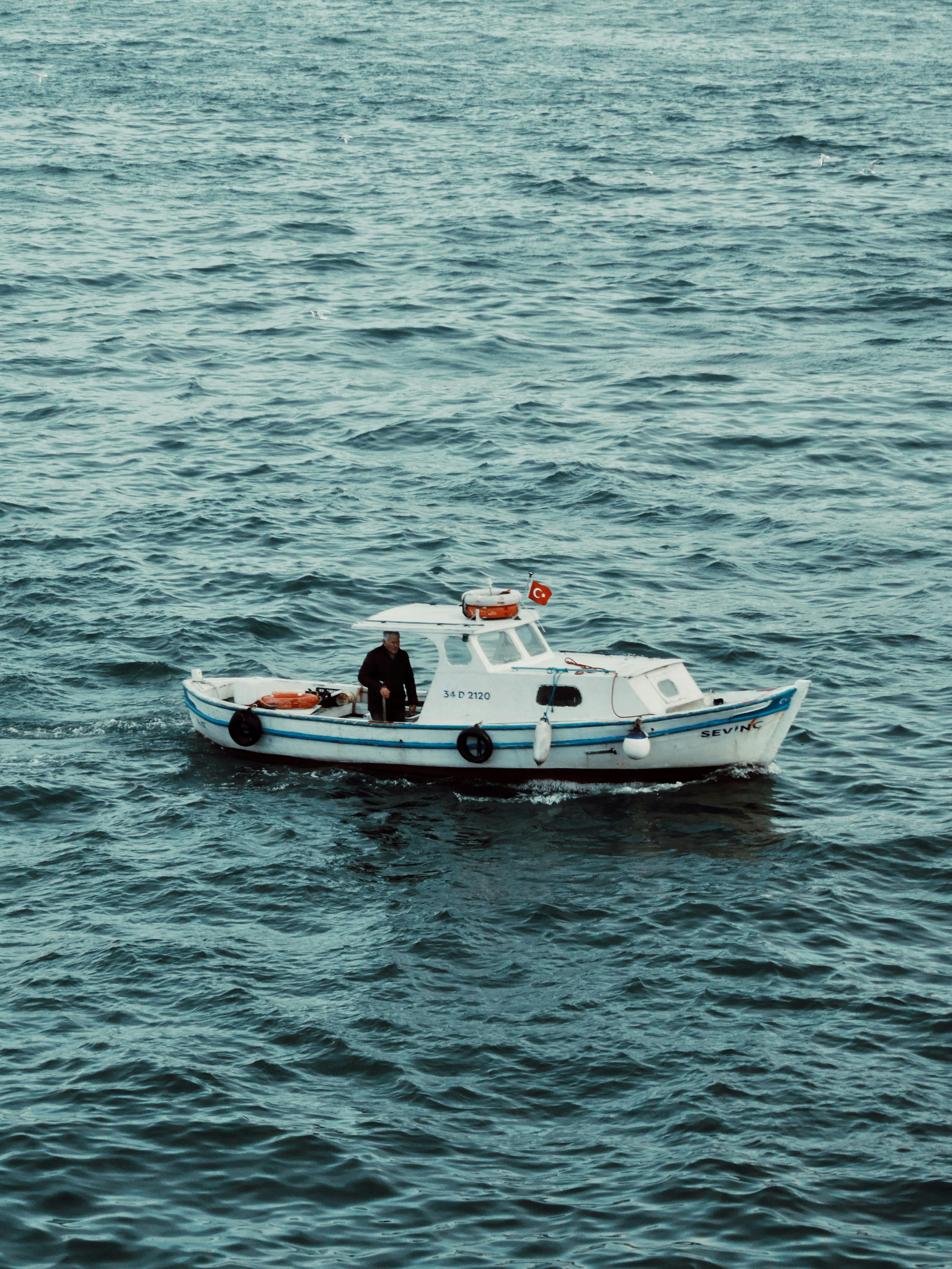 grátis Um pequeno barco de pesca navega pelo mar perto de Istambul, mostrando o cotidiano da vida marinha. Foto profissional