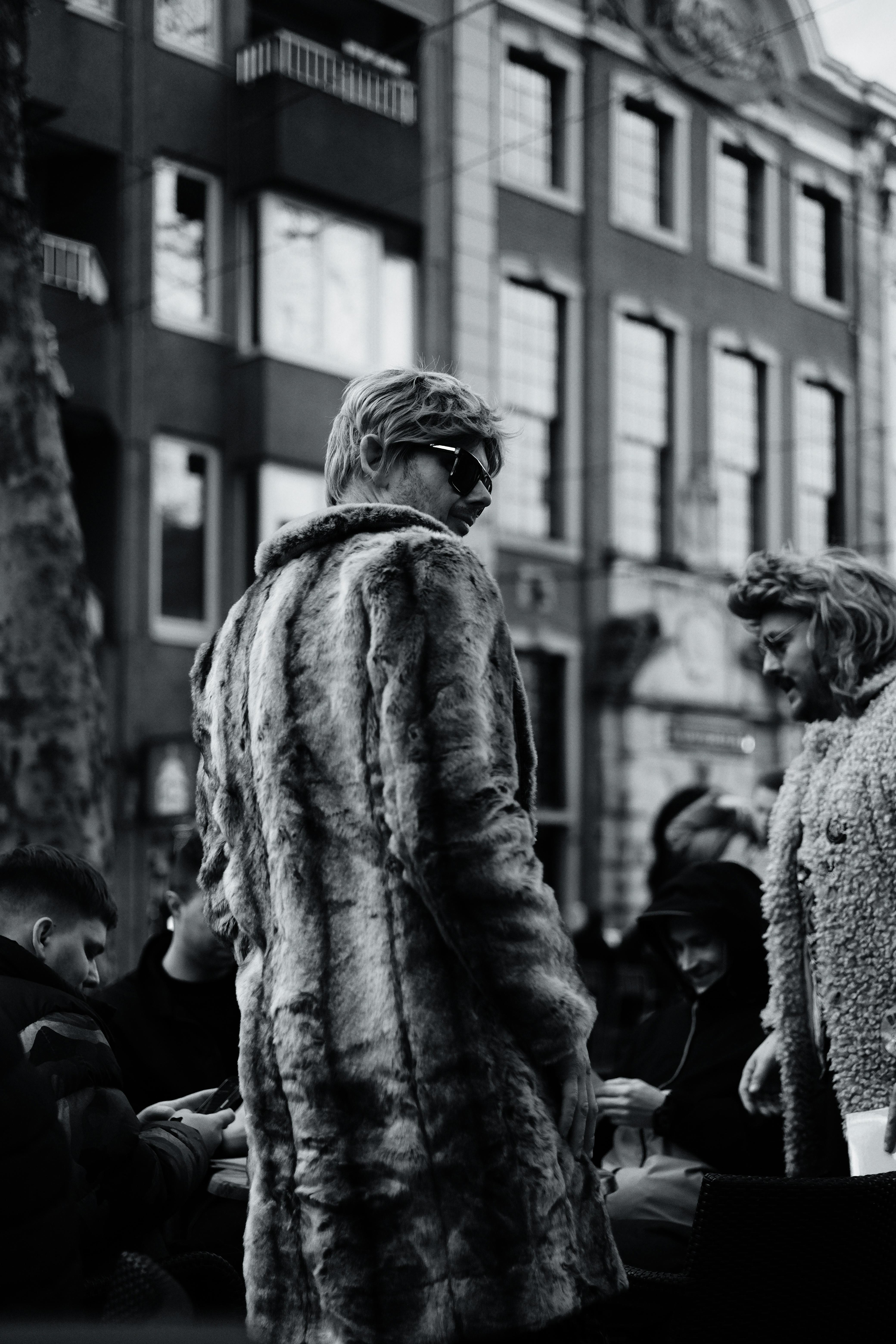 免费 在都市街头聚会中，身着皮草大衣的时尚人士。 素材图片