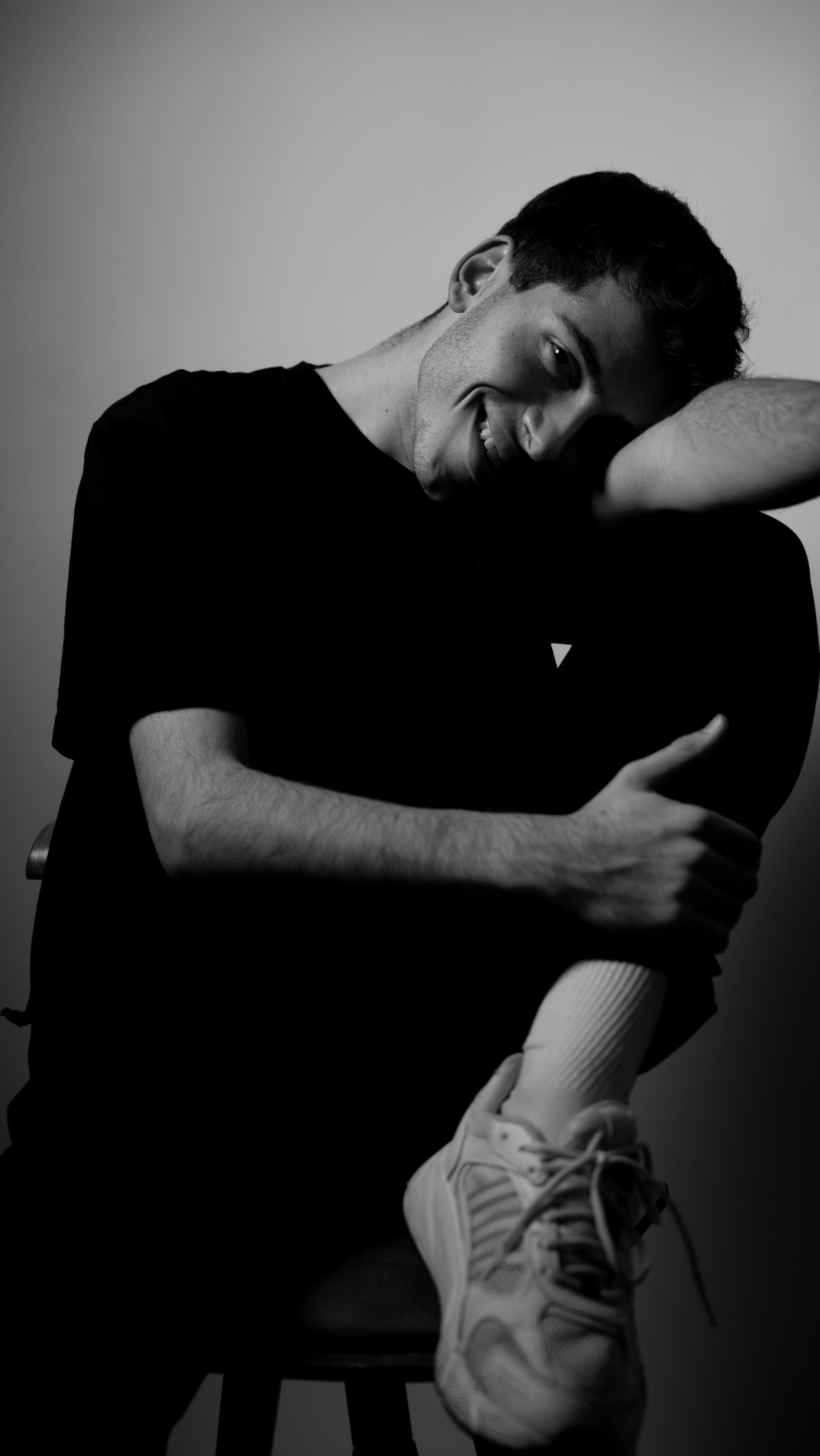 Ücretsiz Düşünceli bir pozda genç bir adamın sanatsal siyah beyaz portresi. Stok Fotoğraflar