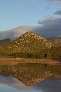 A tranquil mountain reflected in a serene lake at Karapınar, Burdur, Turkey.
