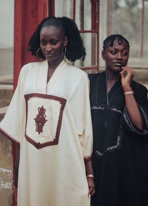 Free Elegant portrait of two women wearing traditional African dresses in an outdoor setting. Stock Photo