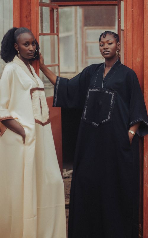 Free Two women in traditional dresses posing elegantly indoors with a rustic background. Stock Photo