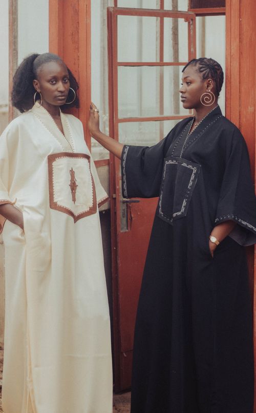 Free Two women posed in stylish traditional dresses, showcasing elegant fashion and cultural attire. Stock Photo