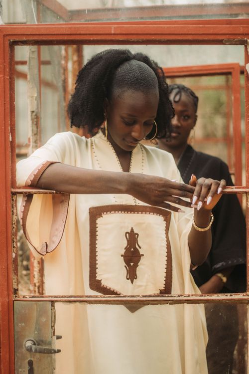 Free Two women in traditional African attire standing in a rustic, earthy setting, conveying cultural elegance. Stock Photo