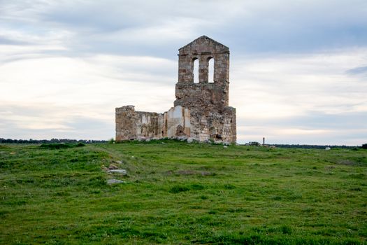 Explore the remnants of an ancient stone structure amidst a vast green field.