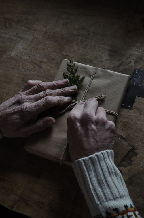 Free A pair of elderly hands tying twine around a rustic, handmade gift with natural decor. Stock Photo