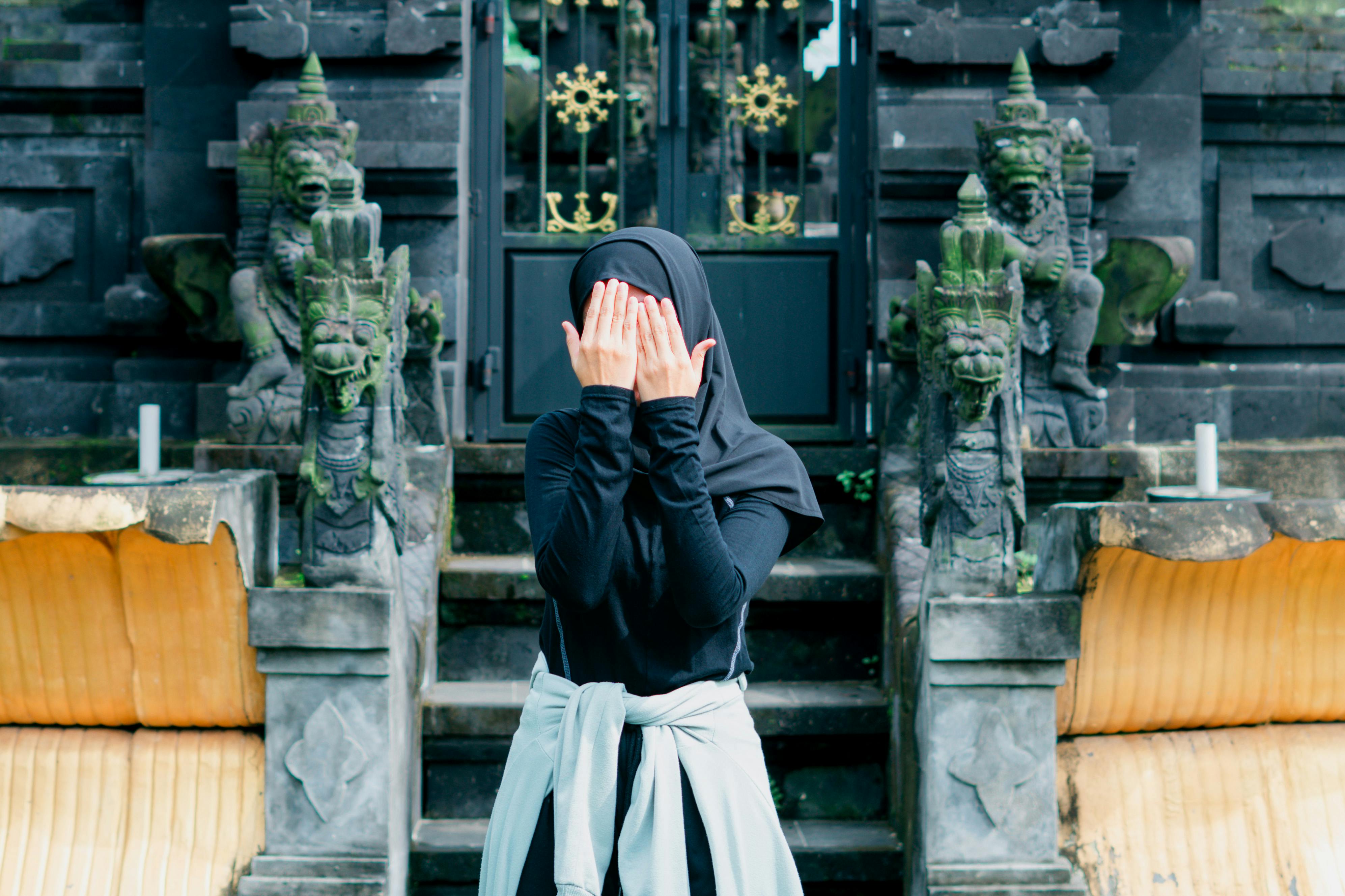 Free A woman in a black outfit poses mysteriously at a traditional temple in Banten, Indonesia. Stock Photo