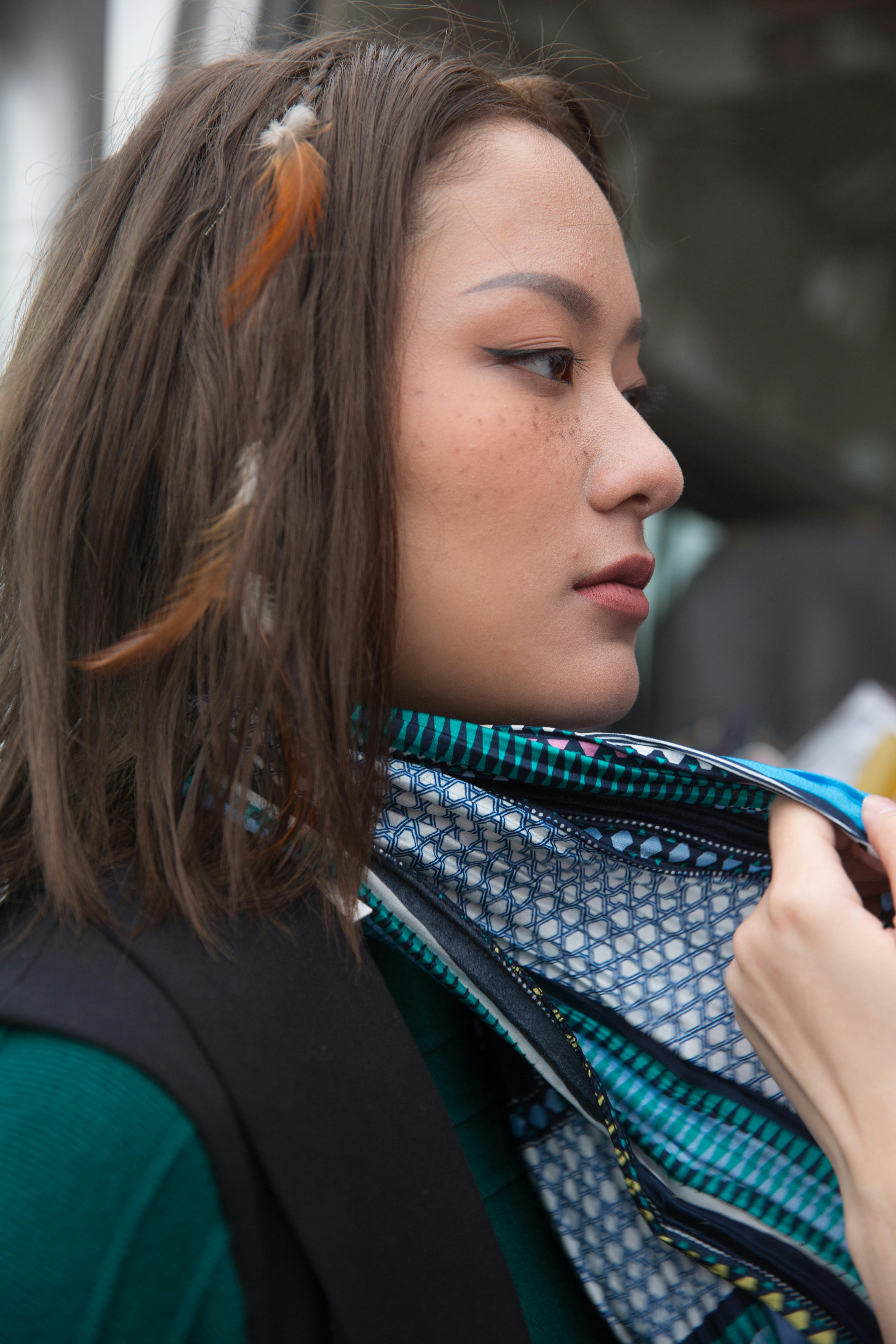 Gratis Primo piano di un profilo di una donna elegante che indossa una sciarpa e un accessorio per capelli con piume. Foto a disposizione